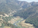 This photo is of some of the scenery mentioned in the previous blurb. This is the head of the Merced River. The road descends into the valley, crosses a bridge over the river and then winds its way back up the next mountain. The road on the other side of the valley is visible in the top-middle of the pic.