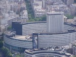 Another large building dwarfed by the Eiffel Tower's height.